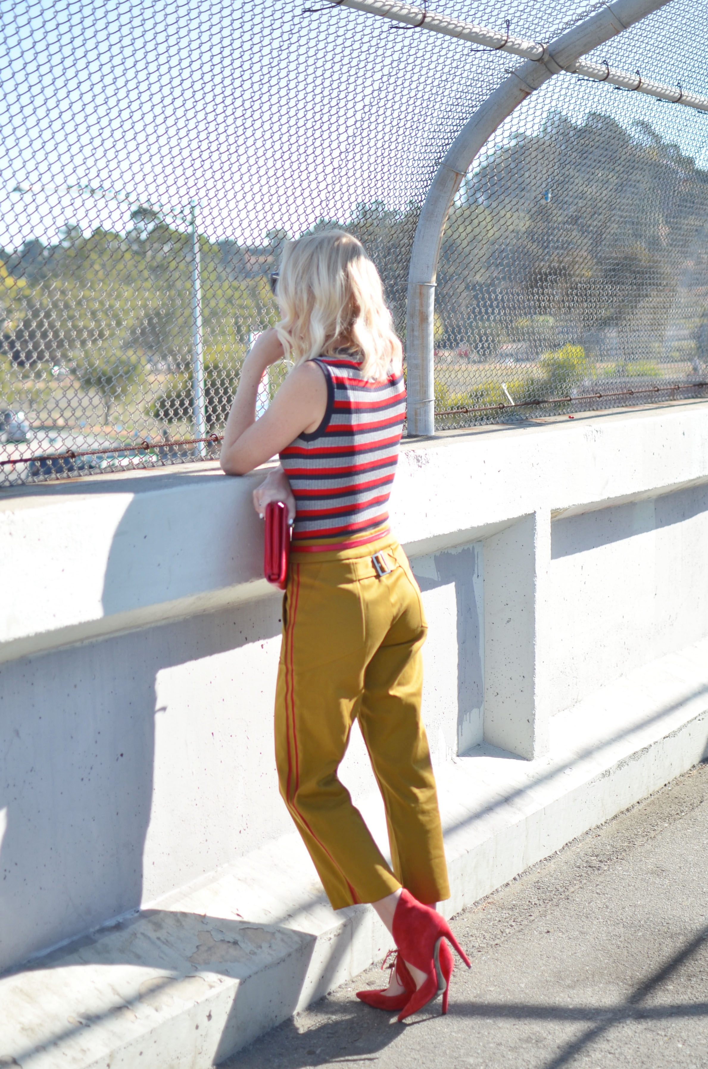 Stefanie of The Style Safari wears a military casual outfit with striped knit tank and pops of red heels and clutch