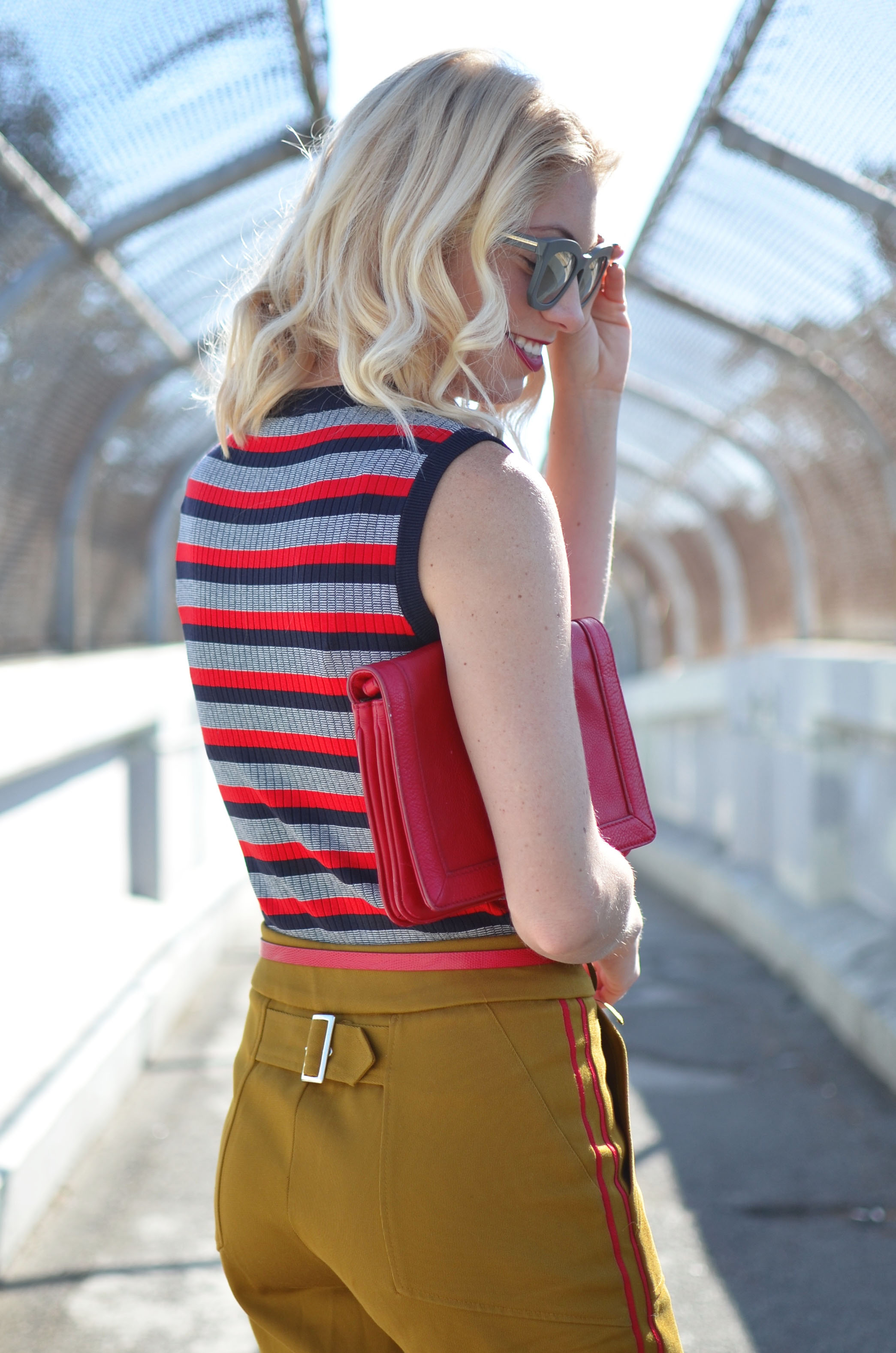 Stefanie of The Style Safari wears a military casual outfit with striped knit tank and pops of red heels and clutch
