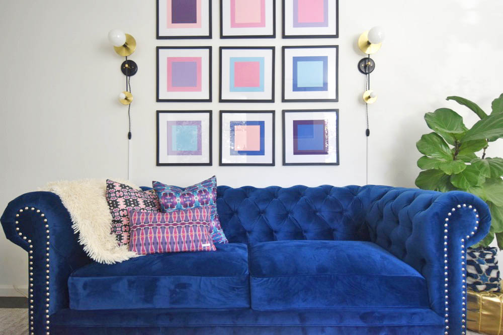 Midcentury glam living room, navy chesterfield sofa, saarinen tulip table, pop art, pink and blue
