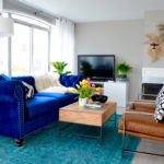 Navy blue velvet chesterfield sofa, cognac leather west elm accent chair, teal vintage persian rug, farrow and ball per beck stone grey walls // thestylesafari.com