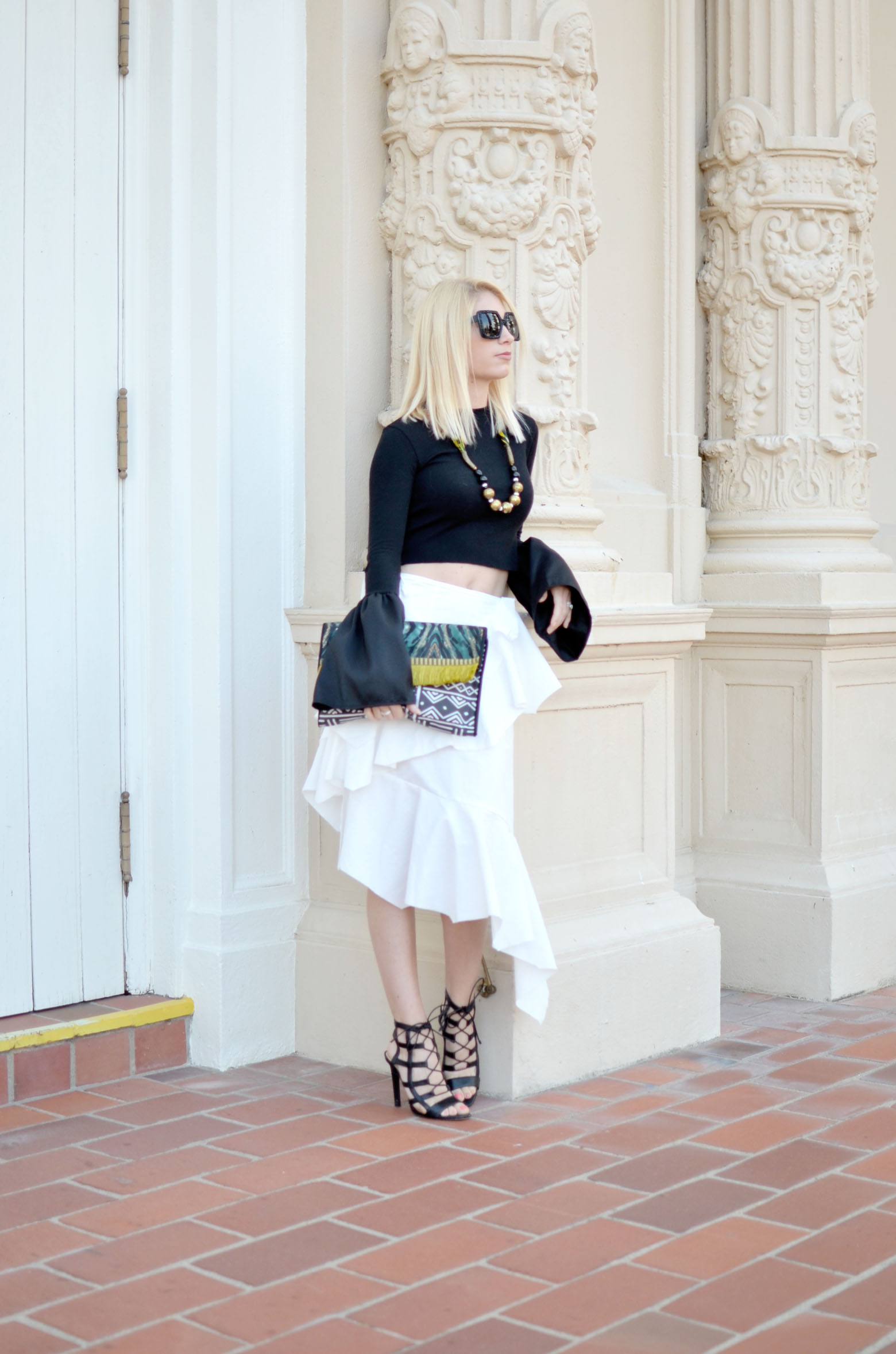 Stefanie of the Style Safari wears storets feel the vibes frayed white skirt, cropped pixie market black top, handmade african clutch and necklace