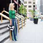 Stefanie from The Style Safari wears a green long sleeve sweater, vertical stripe wide leg pants, black and white graphic clutch // thestylesafari.com