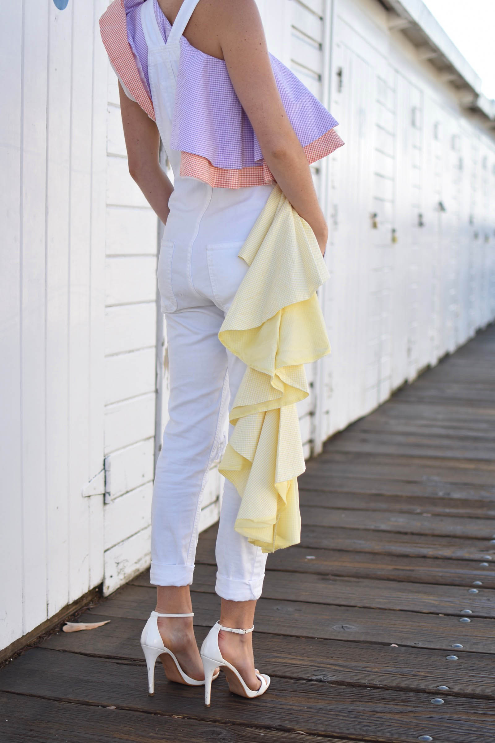 white modern overalls, styled with pastel ruffle top,