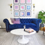 Midcentury glam living room, navy chesterfield sofa, saarinen tulip table, pop art, pink and blue, eames lounge chair